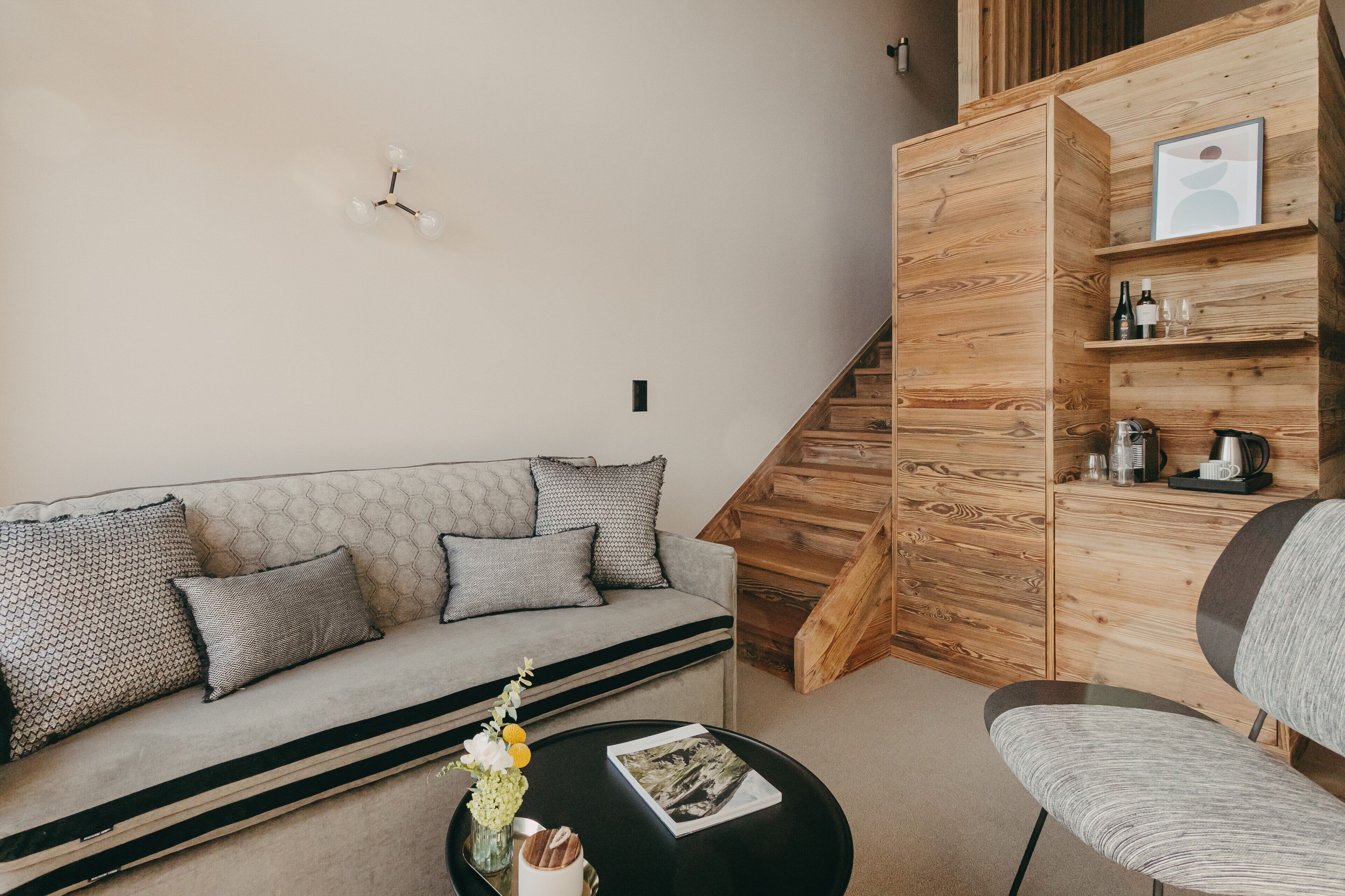 Ein modernes Wohnzimmer mit einer Couch, einem Couchtisch und einer Holzkommode mit Regalen.