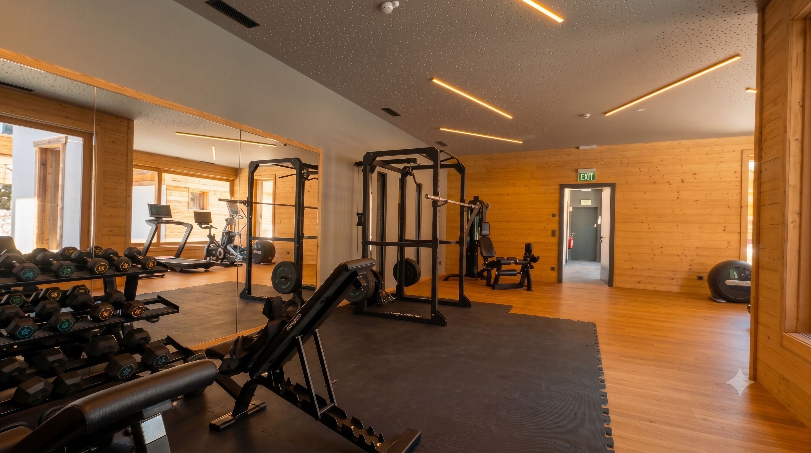Une salle de sport équipée de matériel d’exercice, d’un tapis de course et d’un banc de musculation.