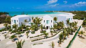 A resort with two white buildings surrounded by palm trees and a beach. - SulMare at Taylor Bay Luxury Villas (Providenciales)