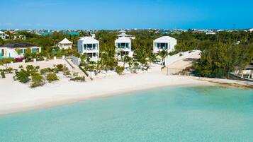 Enjoy expansive ocean views from the comfort of your villa, surrounded by lush greenery and a sandy beach.