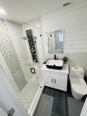 A modern bathroom with a glass-enclosed shower, a white sink, and a toilet. - 3 bedroom accommodation in Hollywood (Hollywood)