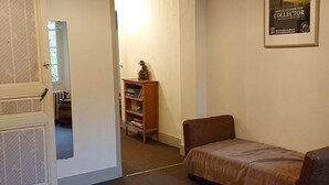 A room with a bed, a wooden chair, a bookshelf, and a poster on the wall.