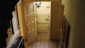 A staircase leading to a room with a patterned floor and a wooden door.