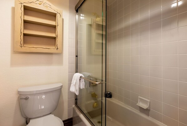 A bathroom with a toilet, a glass shower enclosure, and a bathtub.