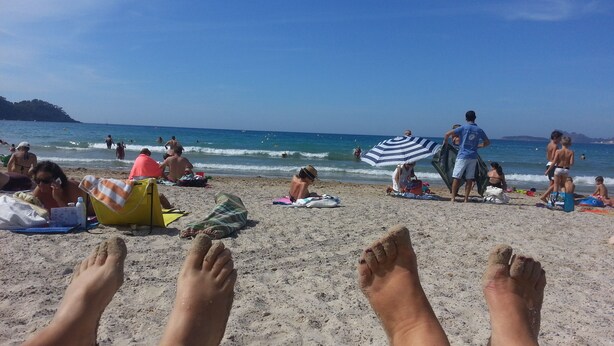 A beach with people sunbathing and swimming, and a person lying down with their feet visible. - T2 recent, air-conditioned, Ideal 50 m from the beach with its private parking space! (Saint-Cyr-sur-Mer)