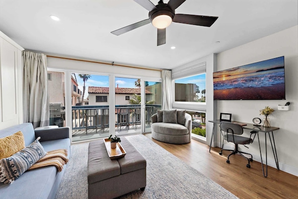 A comfortable living room with plenty of seating and a king-sized sofa Murphy Bed that converts to a "real bed with a premium mattress" in less than one minute. The bed is made up with premium bedding ready for sleep