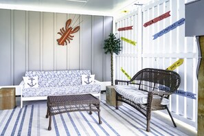 Relax in a nautical-themed room with a sofa, armchair, and striped rug.