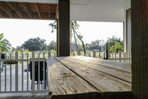 Relax in a serene outdoor space with a shaded table under a pergola, surrounded by trees and a distant view.