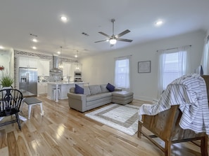 Relax in this inviting space with a central kitchen, comfortable sofa, and dining area.