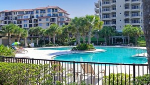 A resort with a large pool, palm trees, and a multi-story building with balconies. - Sea Dunes #1614 - Ocean front! (Nassau County)