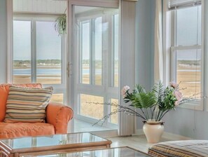 Enjoy stunning beach views from the comfort of this room, featuring a sofa and coffee table.