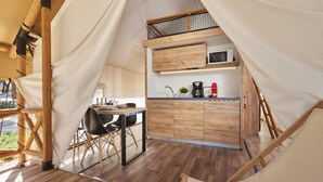 Een kleine keuken met houten kastjes, een magnetron en een koffiezetapparaat.