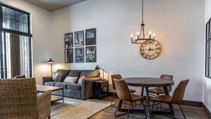 A modern living room with a sofa, dining table, chairs, and a chandelier. - Upscale Lakeview Condo in Downtown Sandpoint (Sandpoint)
