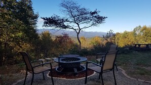 A fire pit with chairs and a table in a garden with a view of mountains. - Mountaintop suite, mountain views, one level, King bed, pet friendly, accessible (Rosman)