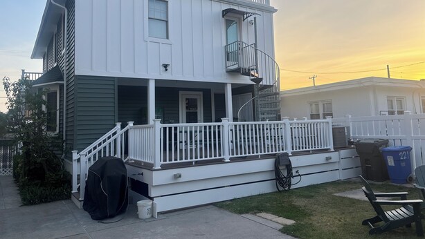 Une maison à deux étages avec un balcon, une véranda et un garage.