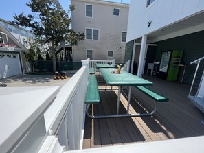 A deck with picnic tables and a barbecue grill. - 1913 Classic Victorian Home with manny outdoor spaces. (Wildwood)