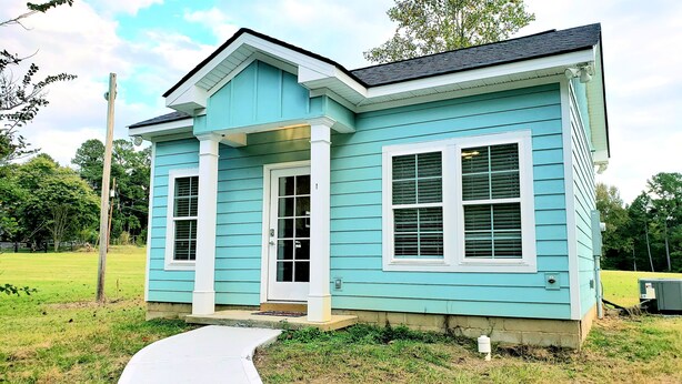 A single-story house with a front porch, a garage door, and a small front yard. - Mulberry Cottage on 16 Acres, King Size Bed, No Pet Fee (Grovetown)