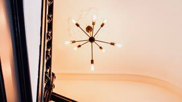 A staircase with a wooden railing and a ceiling light fixture.
