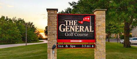 Señal para el General Golf Course con una flecha apuntando a la derecha, indicando el camino al Inn & Spa a 5.6 kilómetros.