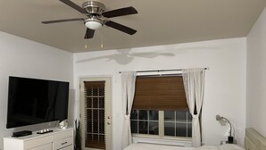 A bedroom with a bed, a TV, a dresser, and a ceiling fan. - Branson, Stone Bridge Resort Studio (Reeds Spring)