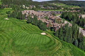 Un campo de golf con un club de campo rodeado de edificios residenciales.