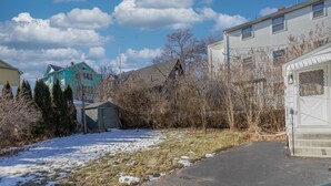 A residential area with houses, a garage, and a snow-covered lawn. - Luxury Home Central to Farmington, Plainville & Downtown New Britain (New Britain)