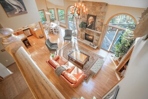 A spacious living area with a fireplace, a stone accent wall, and a view of the outdoors.