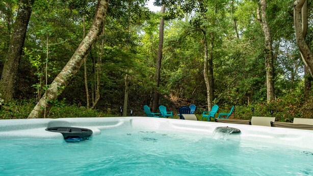 A hot tub surrounded by trees in a forested area. - Family Entertainment Beach House, Hot tub, Nature Park, Fire pit, Pizza Oven (Emerald Isle)