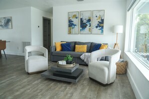 A modern living room with a grey sofa, two white armchairs, a coffee table, and abstract art on the wall. - ☀️🏝😎 MIAMI PARADISE - 11 people 🛌 (Miami)