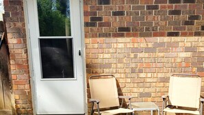 A front door with a window, two metal chairs, and a brick wall. - Entire Townhome Your GameDay Getaway 5Miles away from Sanford Stadium (Athens)