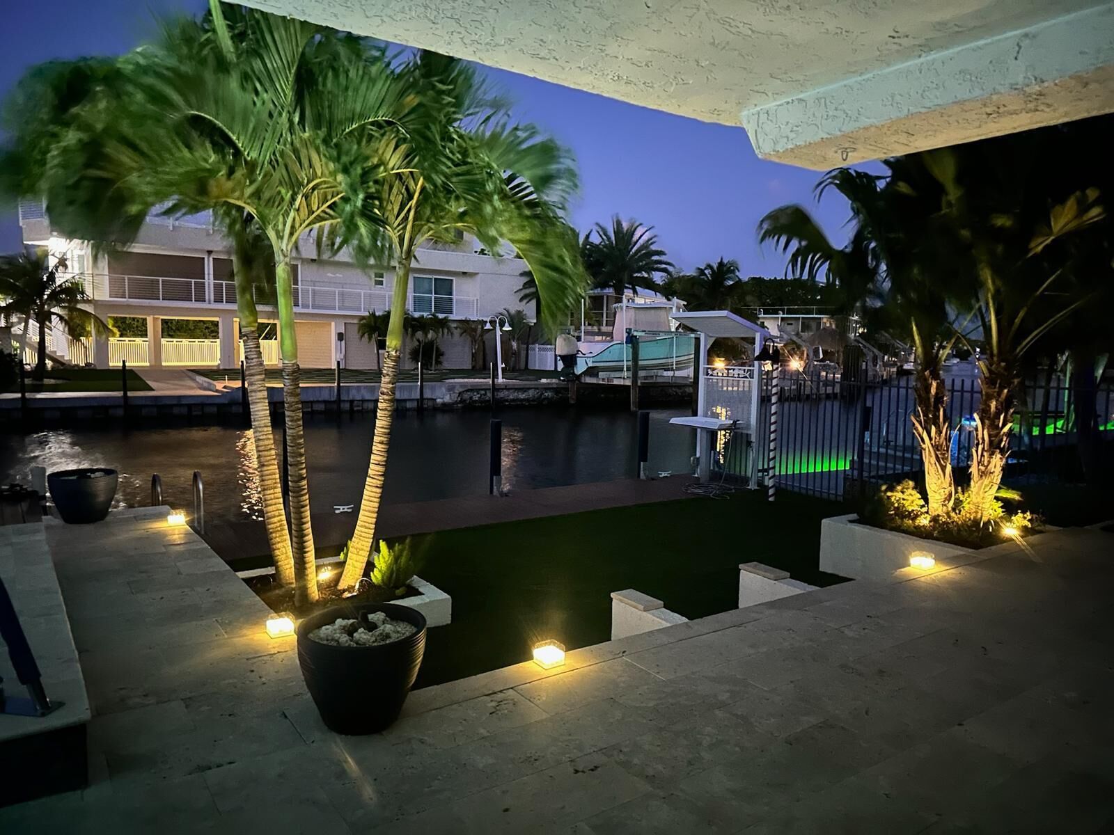 A pool area with palm trees and a view of a building in the background.