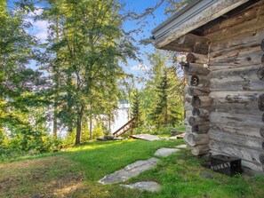 A log cabin with a stone staircase leading to a wooden deck. - Kelosyväri 17 by Interhome (Nilsiä)