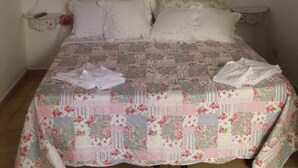 Ein Bett mit einer floralen Stegdecke, einem Baldachin und zwei Nachttischen mit Lampen.