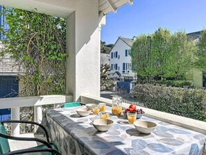 Un balcon avec une table préparée pour le petit-déjeuner, comprenant des bols, des verres et des fruits.