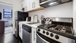 Een moderne keuken met roestvrijstalen apparatuur, een vaatwasser en een fornuis.