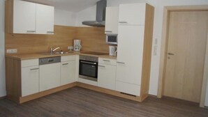 A modern kitchen with white cabinets, a dishwasher, an oven, a microwave, and a coffee maker. - Apartment "Gertis Top 2" with Mountain View, Wi-Fi & Balcony (Stumm)