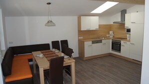 A compact kitchen with a dining area, a built-in oven, and a dishwasher. - Apartment "Gertis Top 2" with Mountain View, Wi-Fi & Balcony (Stumm)