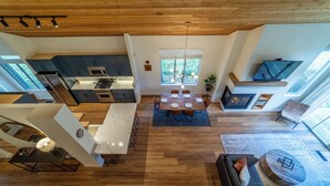 A spacious living area with a dining table, sofa, and a fireplace. - Snowcreek Luxury Remodel 529 (Mammoth Lakes)