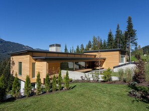 A modern house with a flat roof, large windows, and a wooden exterior. - Kadenwood 2980 - Ski in Ski out, Private Pool, Hot Tub & Gondola (Whistler)