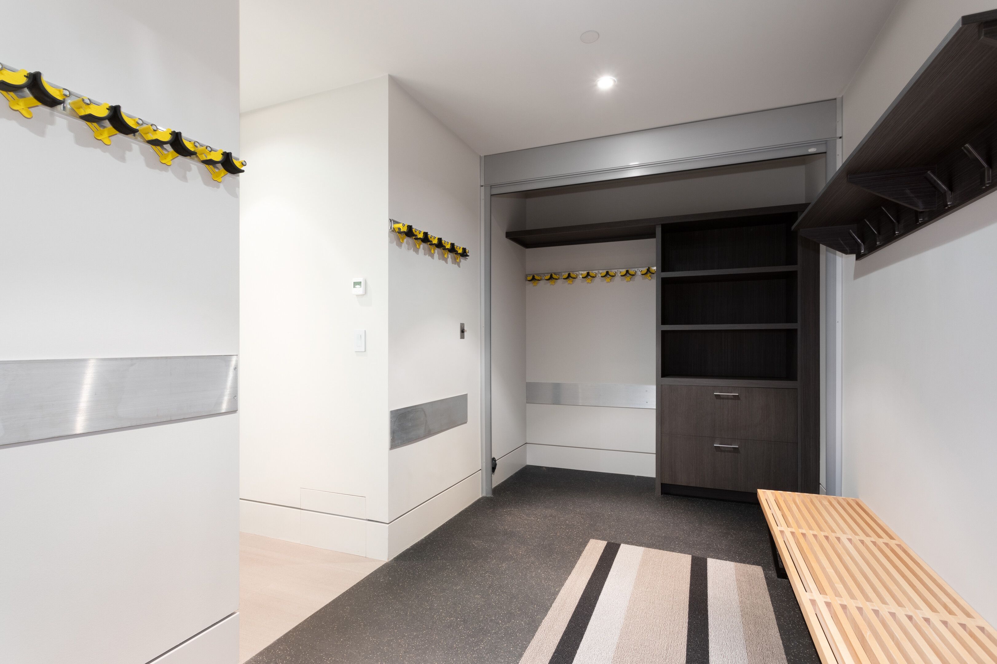 A modern hallway with a coat rack, a bench, and a wardrobe.