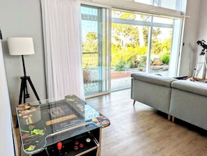Una habitación con una mesa de vidrio, un sofá, una lámpara y un telescopio.