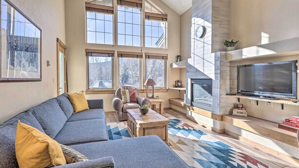 A spacious living room with a large sectional sofa, a fireplace, and a television. - Frisco Condo w/ Balcony: 7 Mi to Copper Mountain! (Frisco)