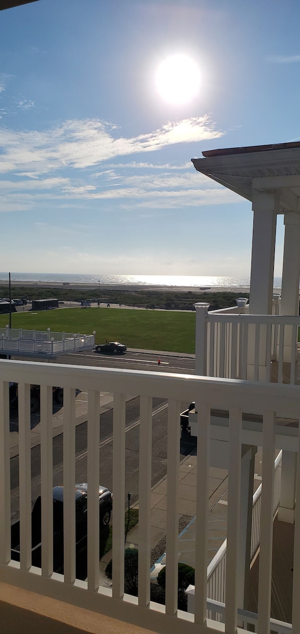 A balcony with a view of a beach and airport.