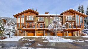 Ein großes, mehrstöckiges Chalet mit zentralem Eingang und mehreren Balkonen.