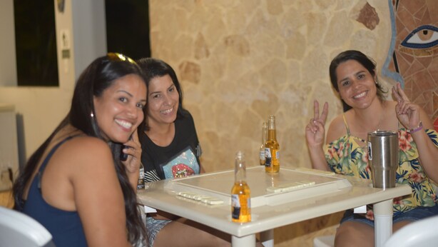 A group of people sitting at a table with bottles and a mug, in a room with a stone wall and a mural. - Sleeps 12 apartment #7, pool, jacuzzi, beautiful property (AGUADILLA)