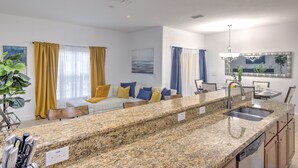 A modern kitchen with granite countertops, a built-in dishwasher, and a sink. - Casita Beth near Disney & Orlando Parks! (Kissimmee)