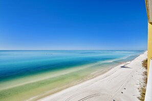 Een strand met helderblauw water en een zandstrand.