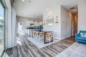 A modern kitchen with white cabinets, a central island, and pendant lighting.