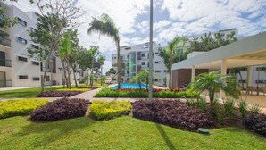 Un hôtel moderne doté d’une cour intérieure avec piscine, de pelouses bien entretenues et d’une grande variété de plantes.