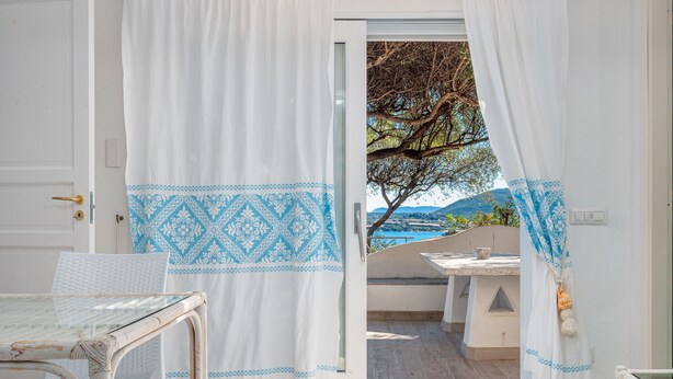 Una habitación con vista al mar, una mesa y una silla.